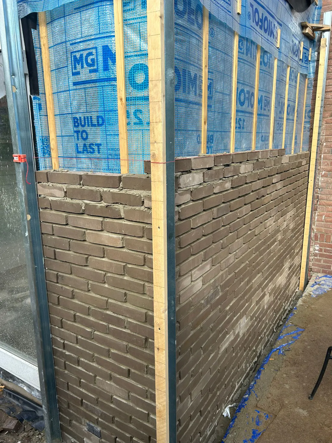 Hoekafwerking van de bakstenen gevel van een aanbouw in uitvoering door PersianTop